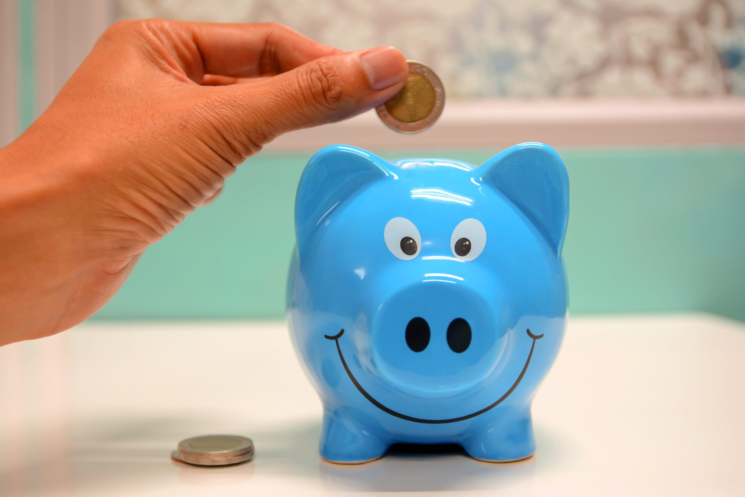 blue piggy bank with coins dropping in