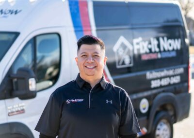 smiling HVAC technician in front of company van